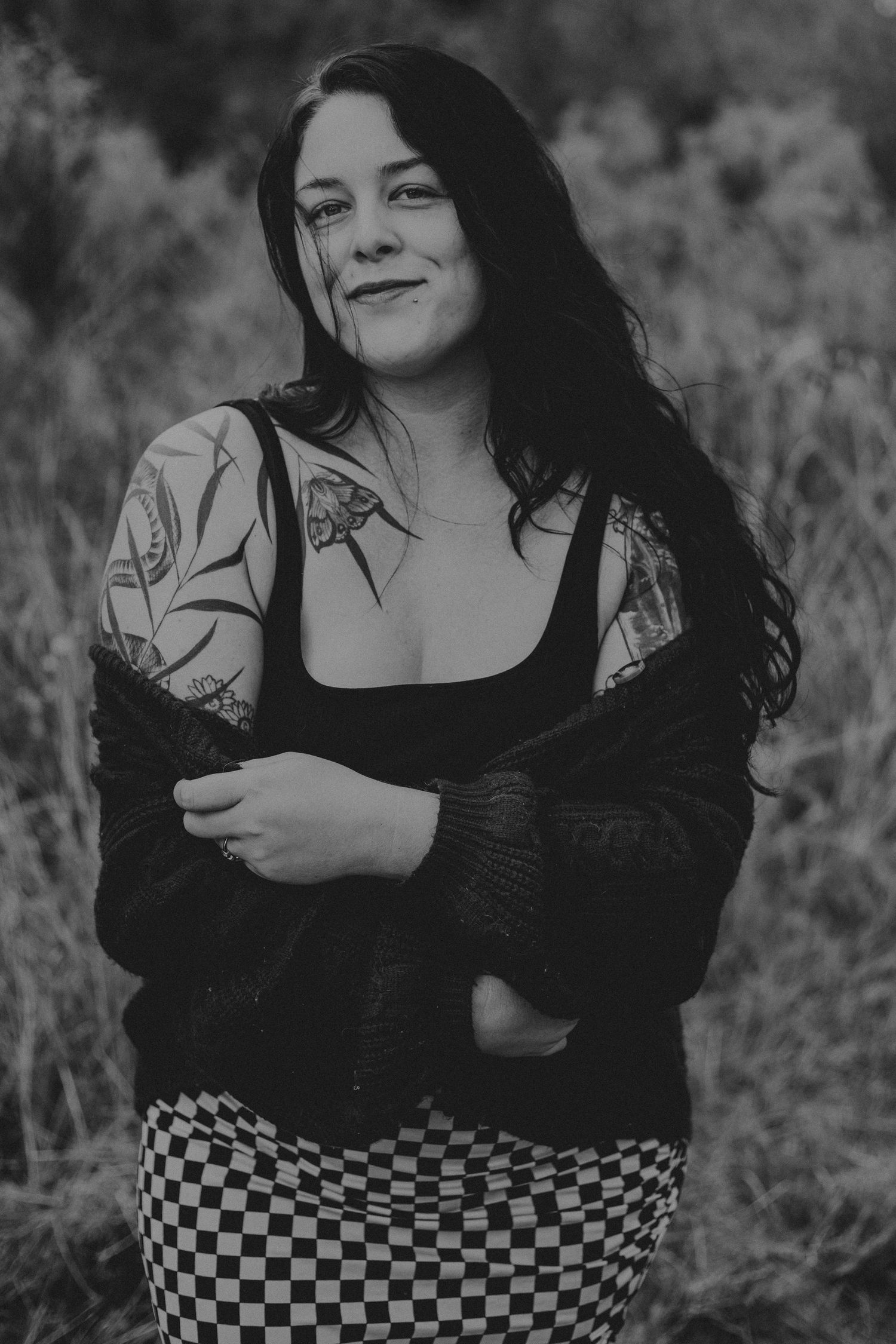 Black and white portrait series showing person in checkered skirt and dark sweater posing expressively outdoors.