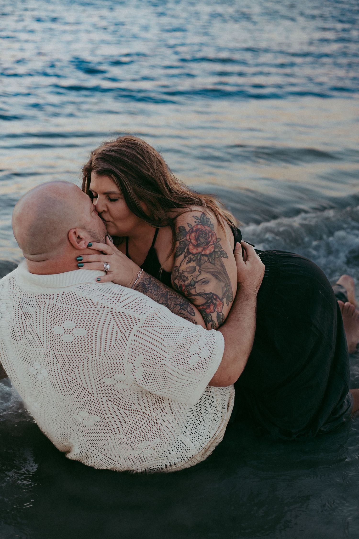 A couple shares an intimate moment by the water's edge in a series of romantic seaside photos.