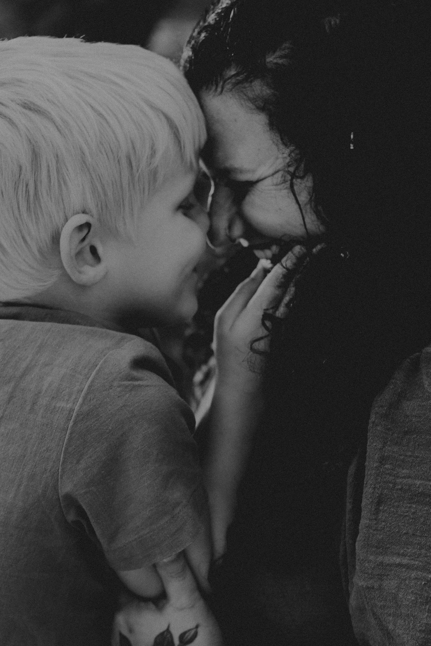 A series of black and white photos showing tender moments between a child and dog in close-up profile views.