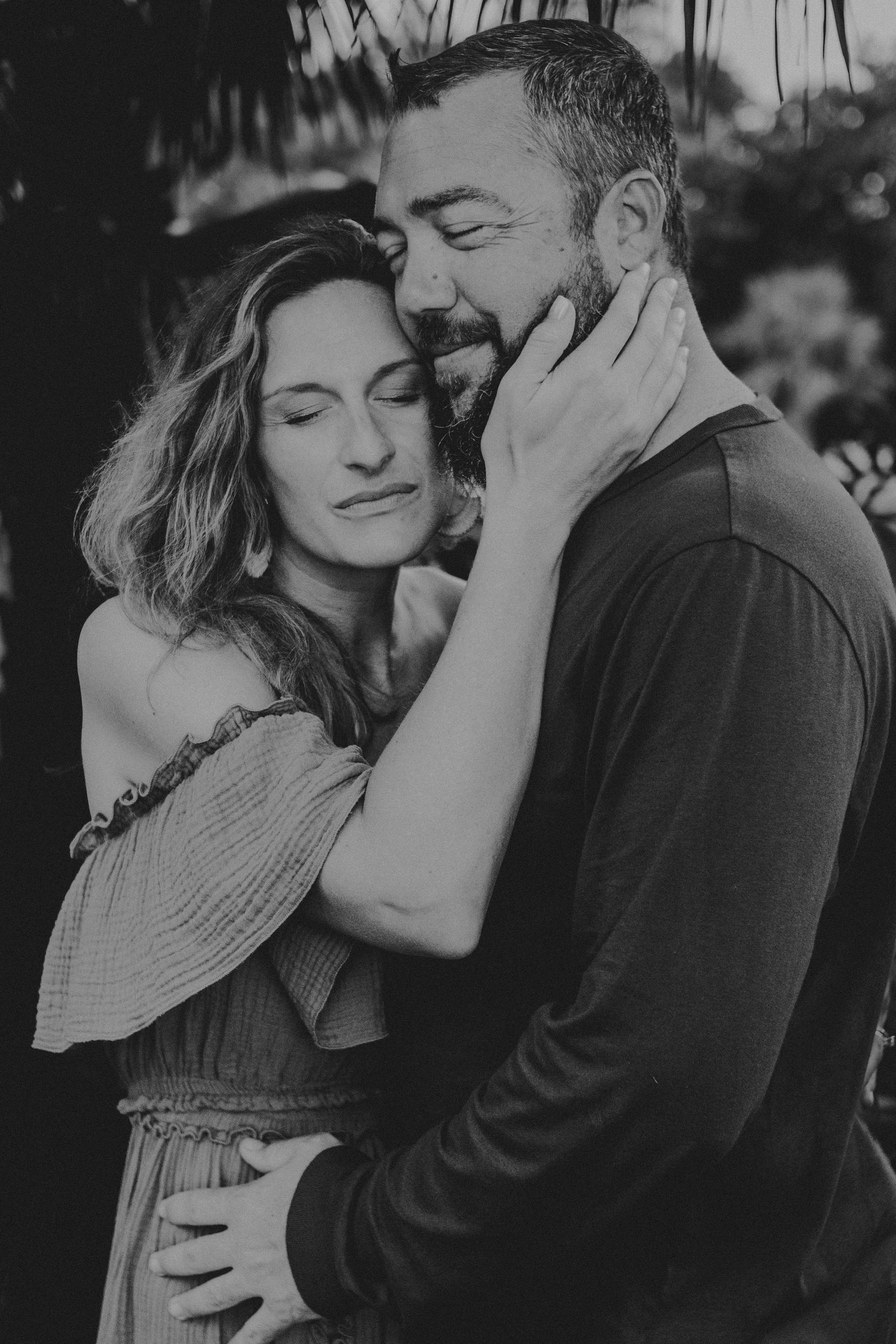 A romantic black and white photo series showing a couple embracing and sharing intimate moments together.