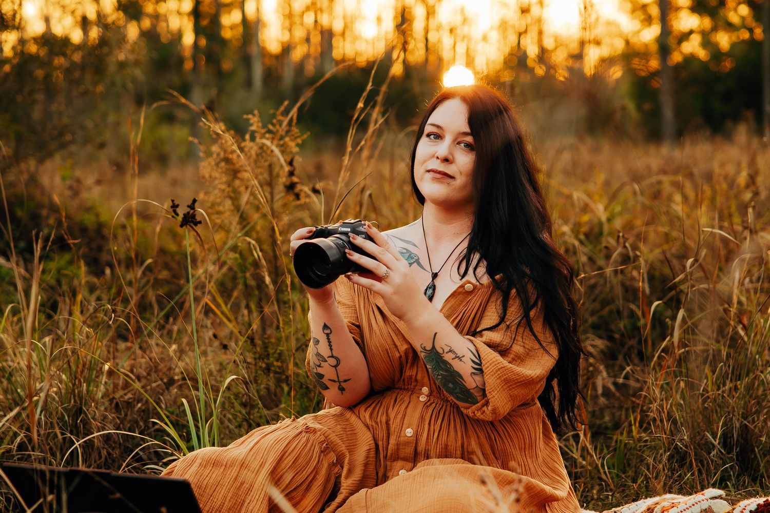Autumn sunset photoshoot in a golden field with warm lighting and vintage camera props.