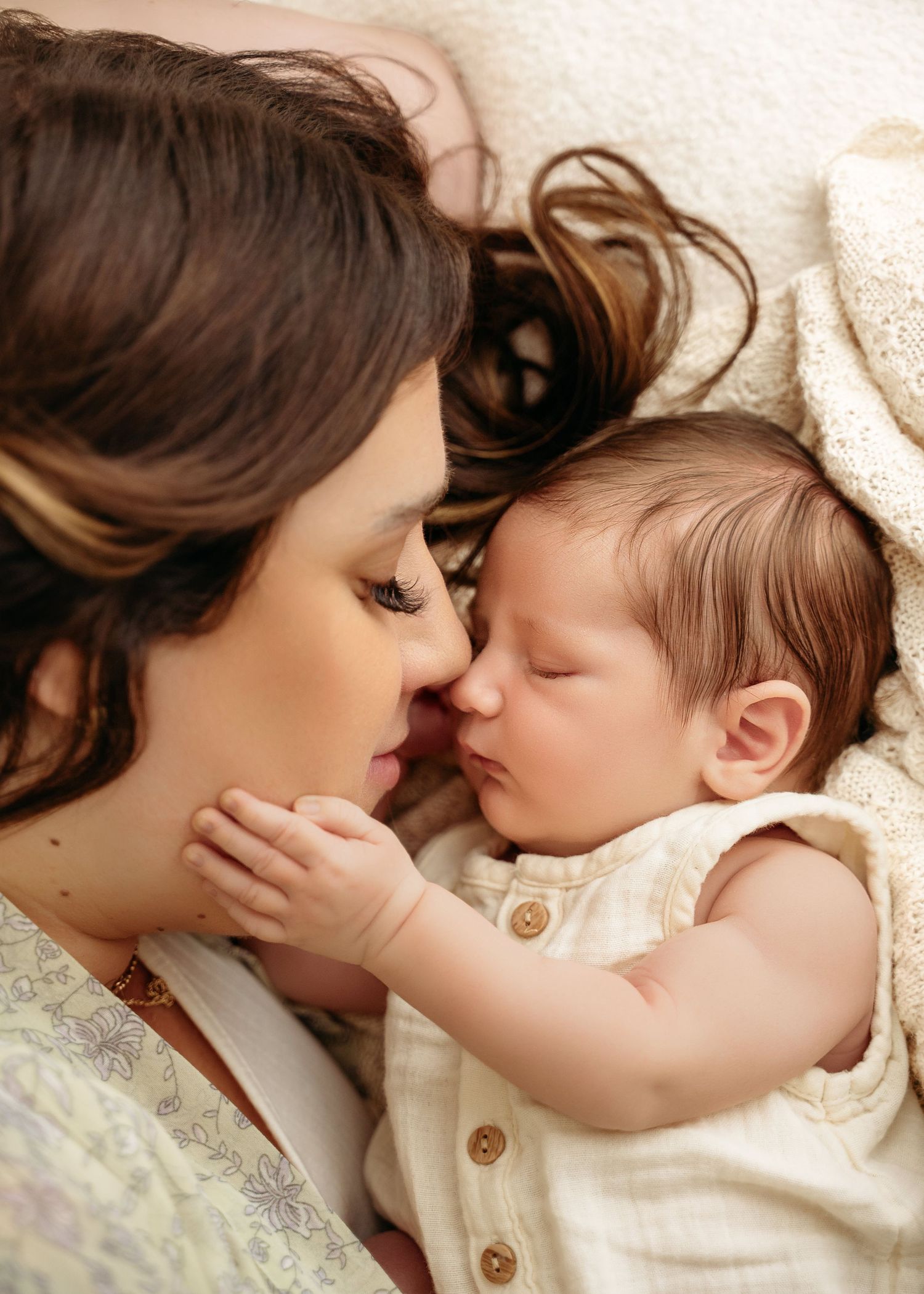 Tender moments shared between parent and child laying together in sequence of intimate close-up photographs.
