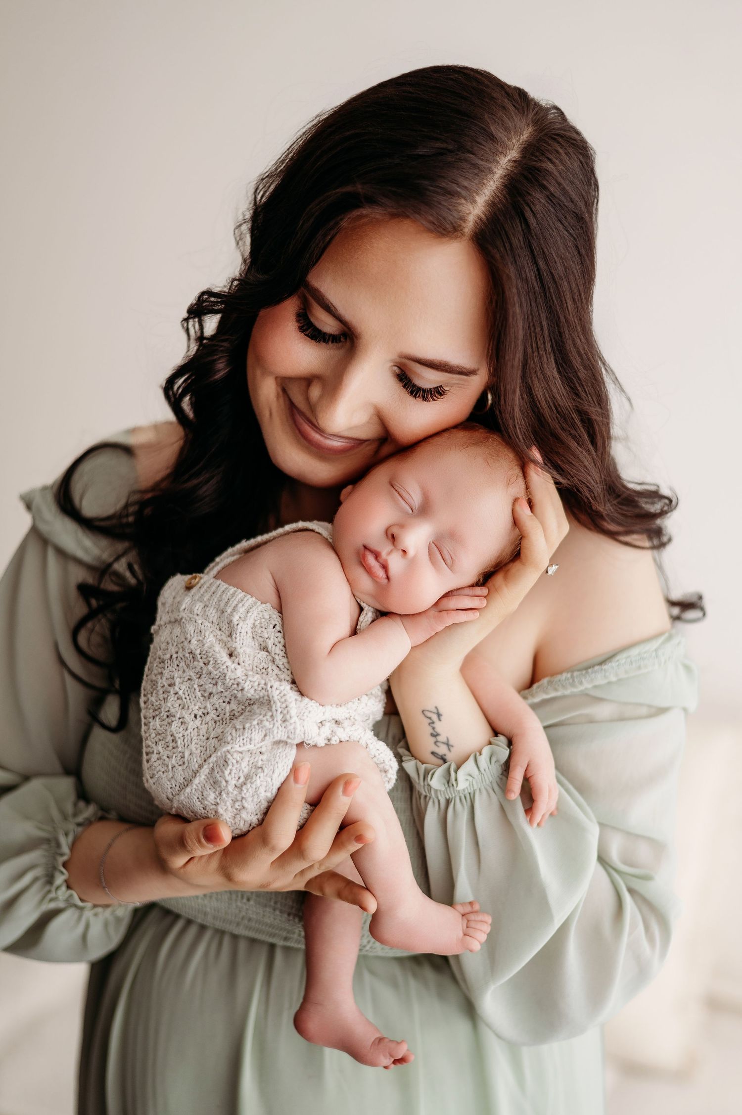 A tender series of photographs showing a parent holding and snuggling with a small infant in soft morning light.