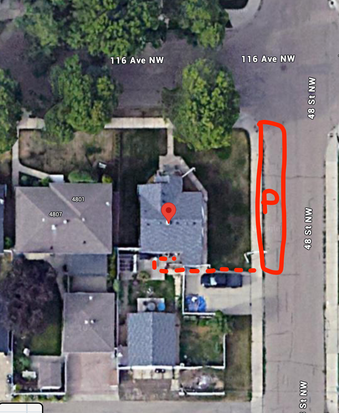 Aerial view of residential rooftops and driveways with red markings visible from above.
