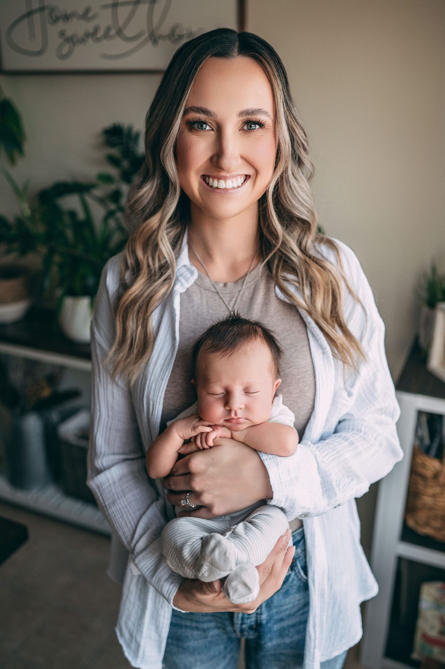 A tender moment between a parent and newborn baby in a white shirt and casual home setting.