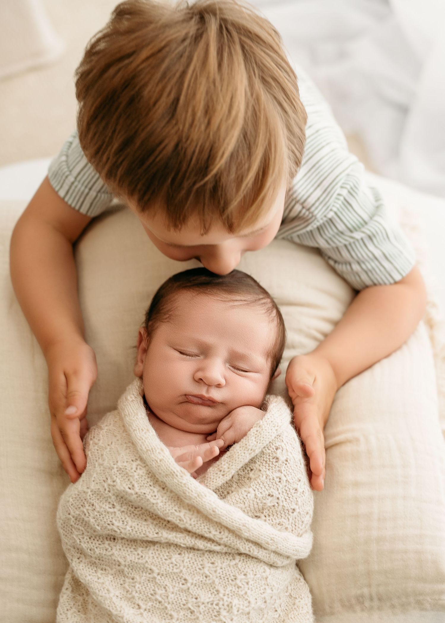 Sleeping baby wrapped in soft cream-colored blanket shown from multiple angles during newborn photoshoot.