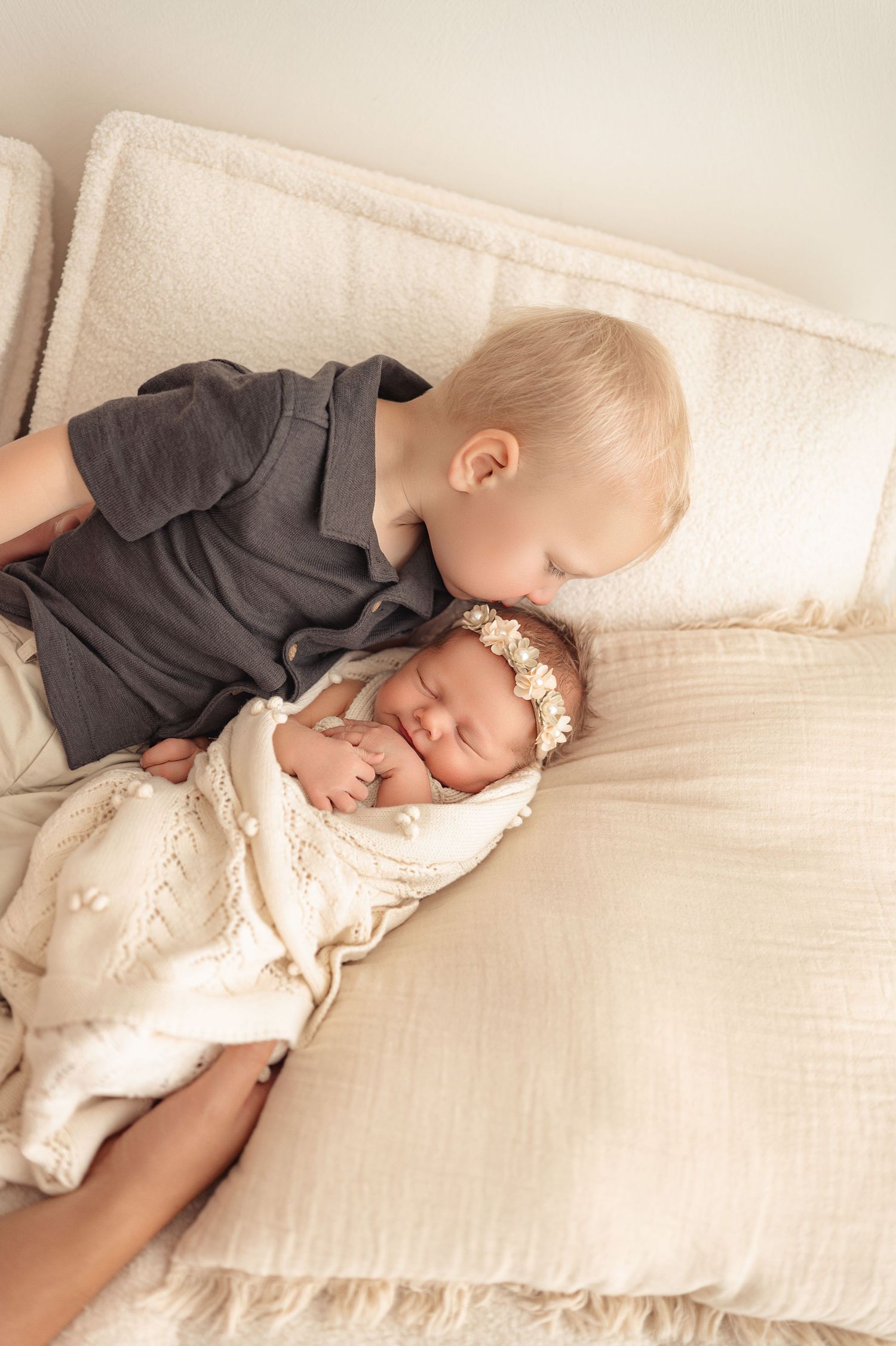 Baby in gray sweater snuggles on white bedding showing peaceful sleeping progression from left to right.