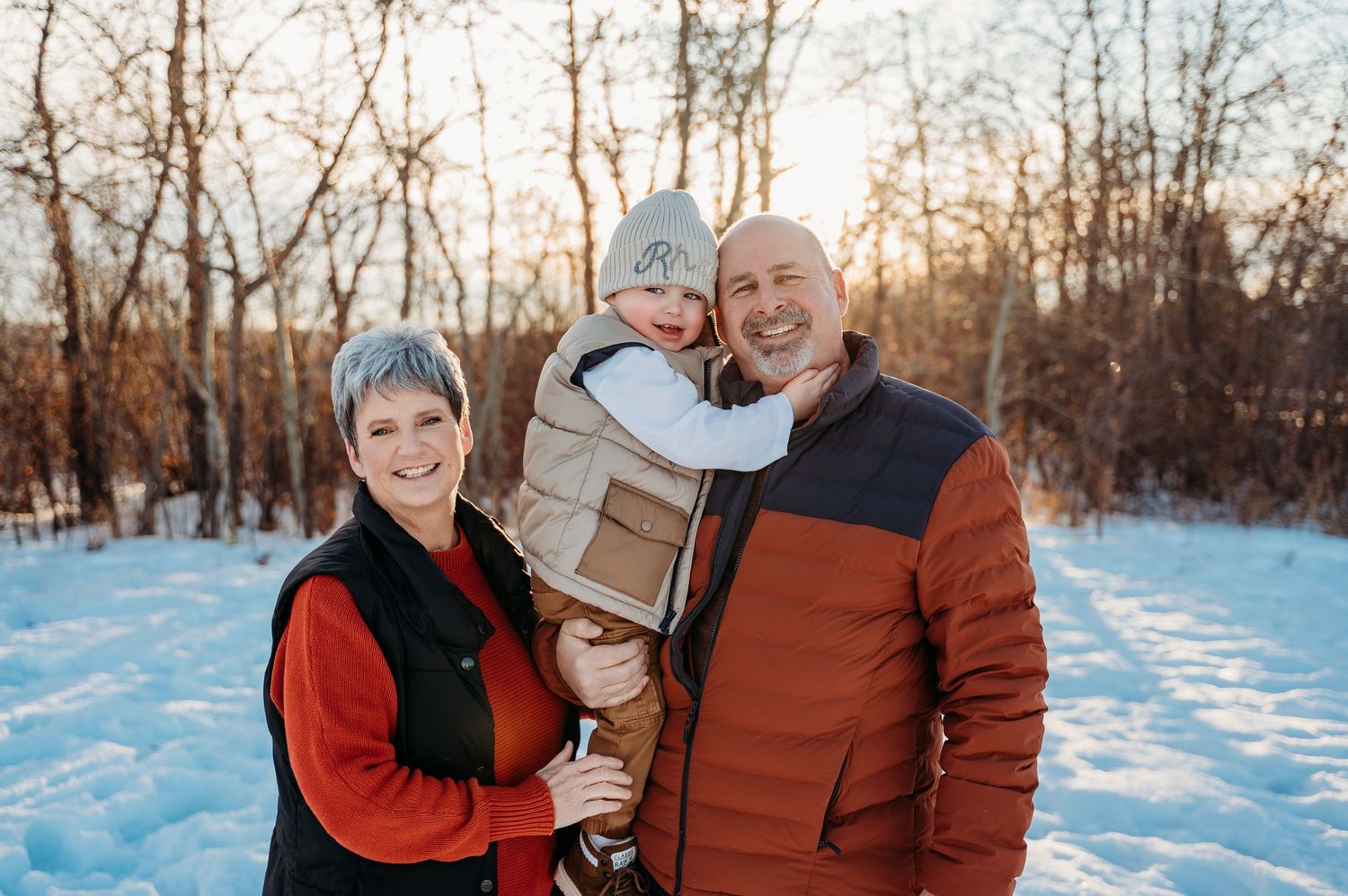 A couple enjoys quality time together outdoors in a snowy winter landscape during sunset.