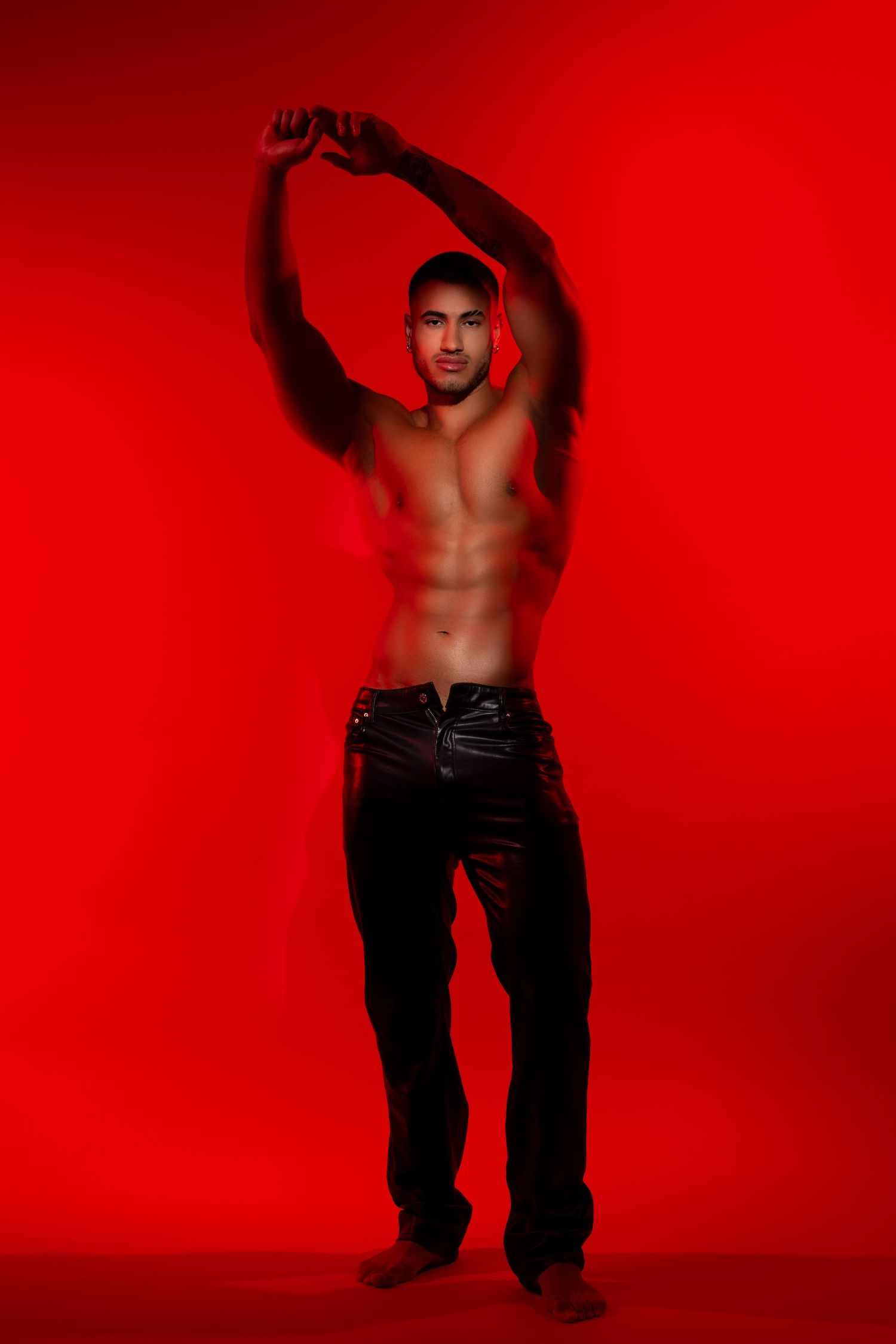 Dramatic red studio photo series showing a shirtless dancer in black pants performing expressive movements against a crimson backdrop.