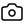 A simple black camera icon with a circular lens, representing photography or image capture functionality.