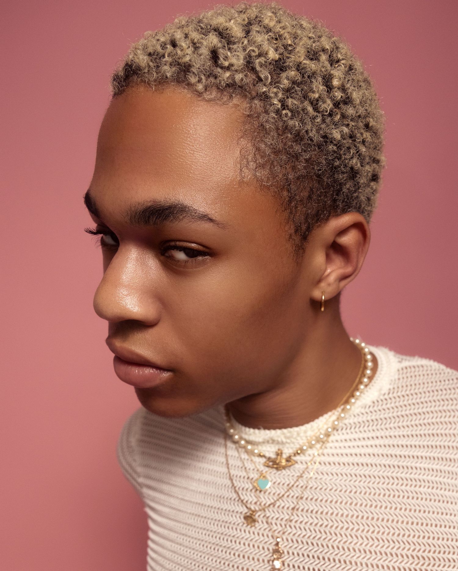 Fashion portrait series showing different angles of a model wearing a cream-colored mesh top against a pink backdrop.