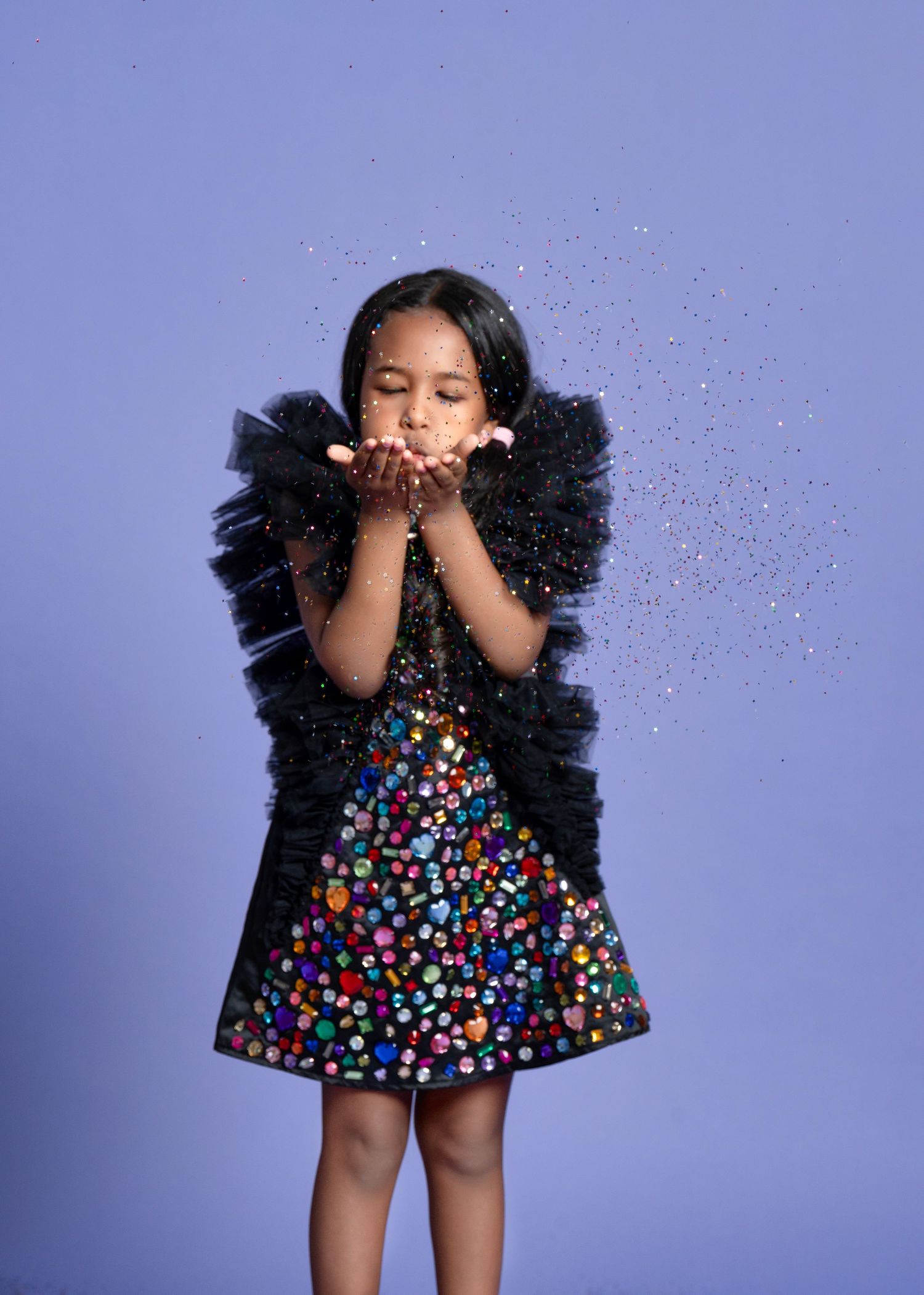 a girl blows sparkles from her outstretched hand