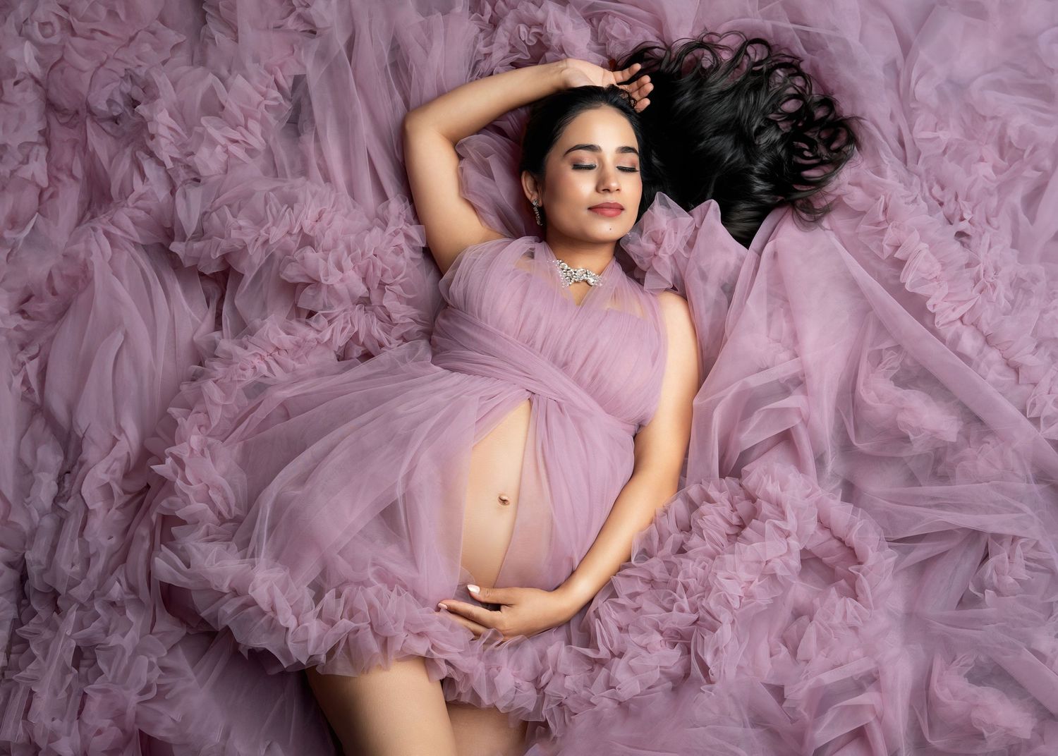 a woman lays in the layers of her purple gown for a session with a minneapolis photographer