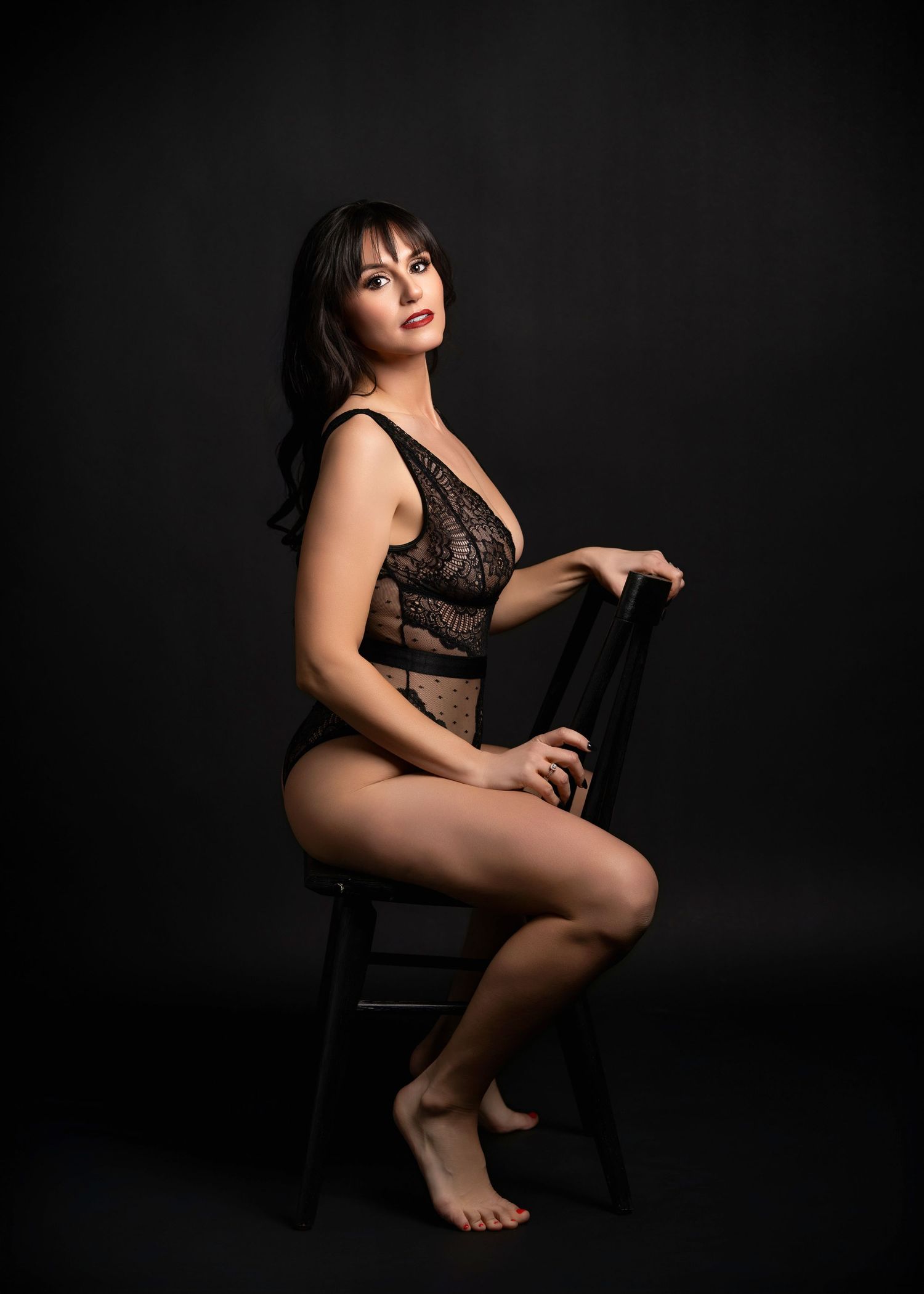a woman leans back in a backwards chair