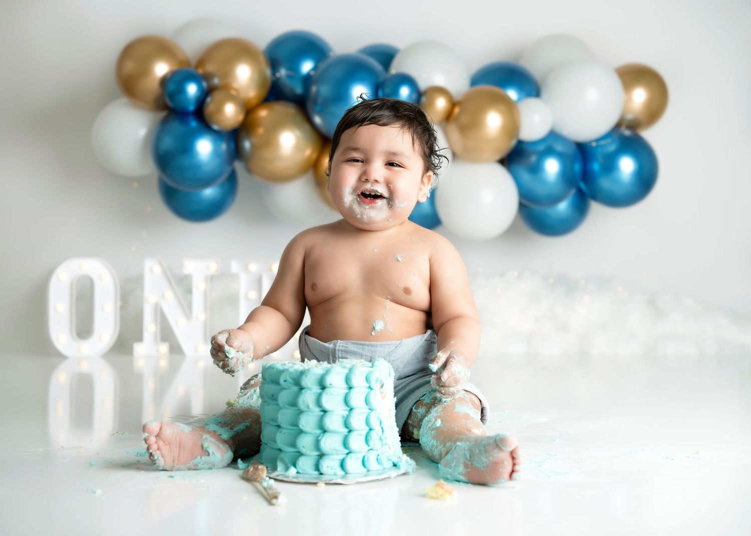 a young boy sits covered in cake during a session with a minneapolis photographer