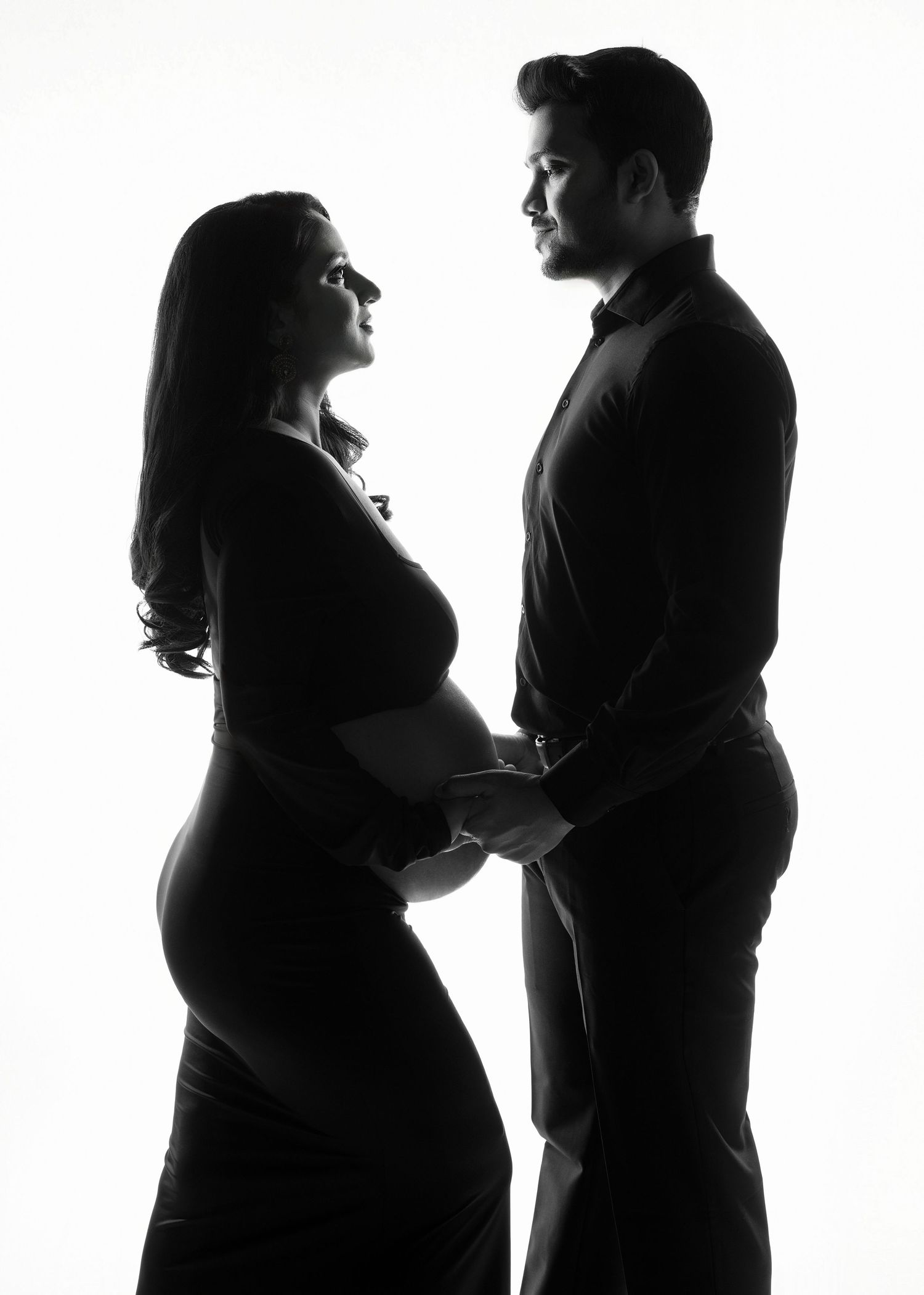 Black and white silhouette portrait of expectant couple in an intimate maternity pose with hands on belly for a minneapolis photographer