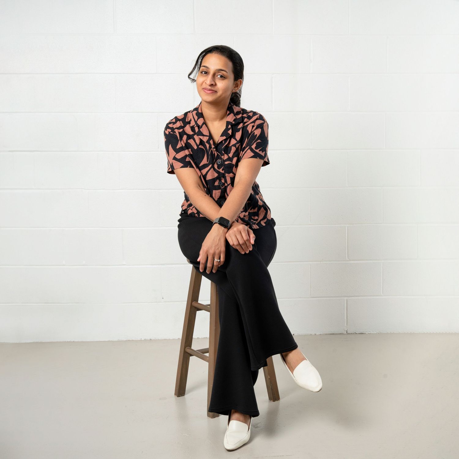 a minneapolis photographer sits on a stool in a bright studio