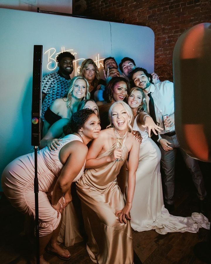 A group of wedding guests dance together on the dance floor during a reception celebration.