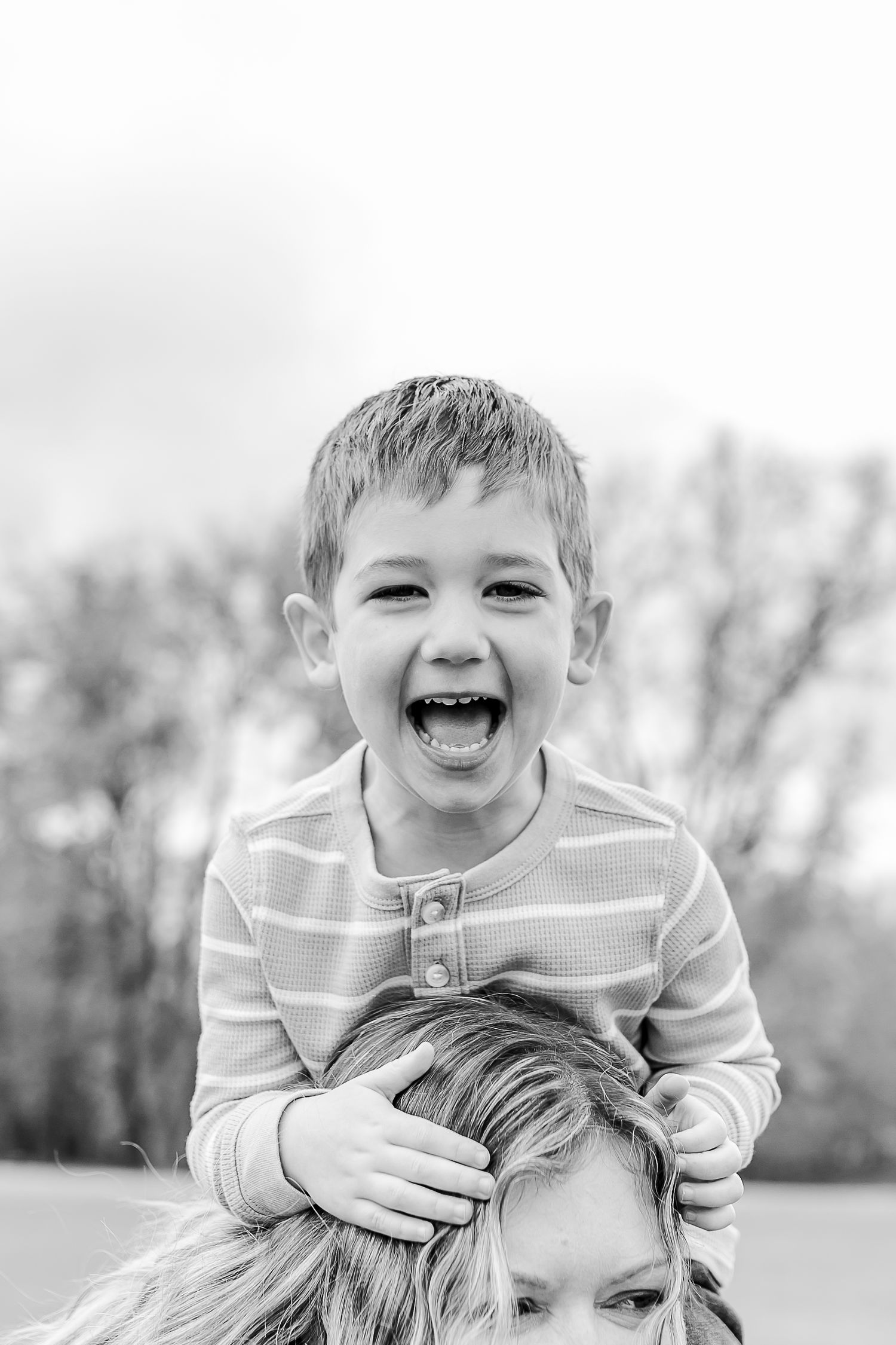 A joyful black and white photo showing two people sharing a tender outdoor moment together.