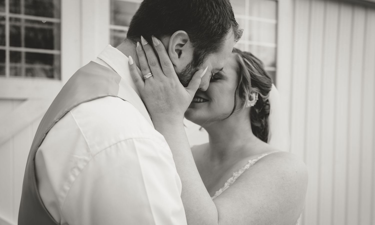 Intimate black and white portrait of couple sharing tender moment outside.