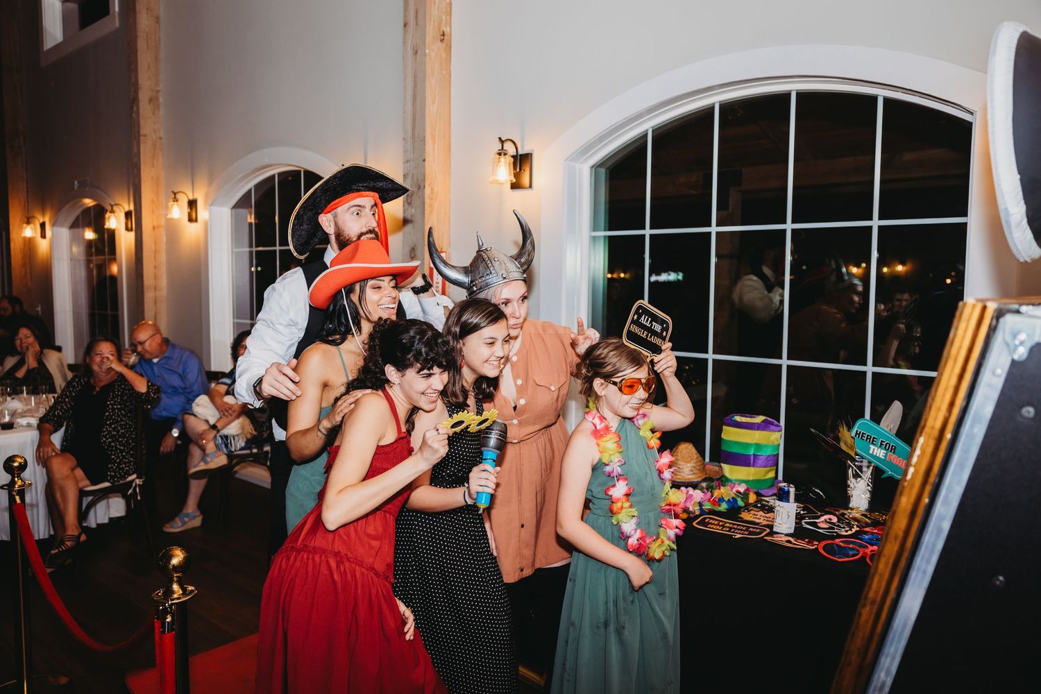 Wedding reception party with guests dancing and celebrating under arched windows.