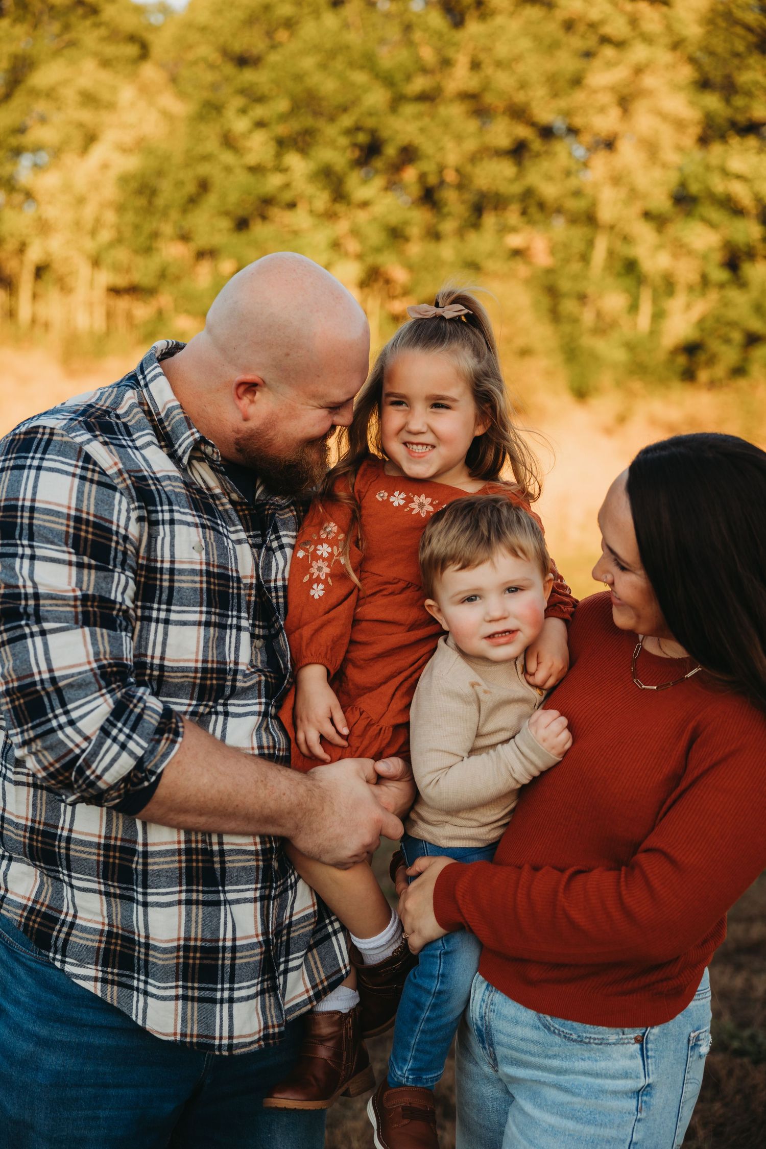 Family in plaid and autumn colors sharing joyful embraces outdoors.