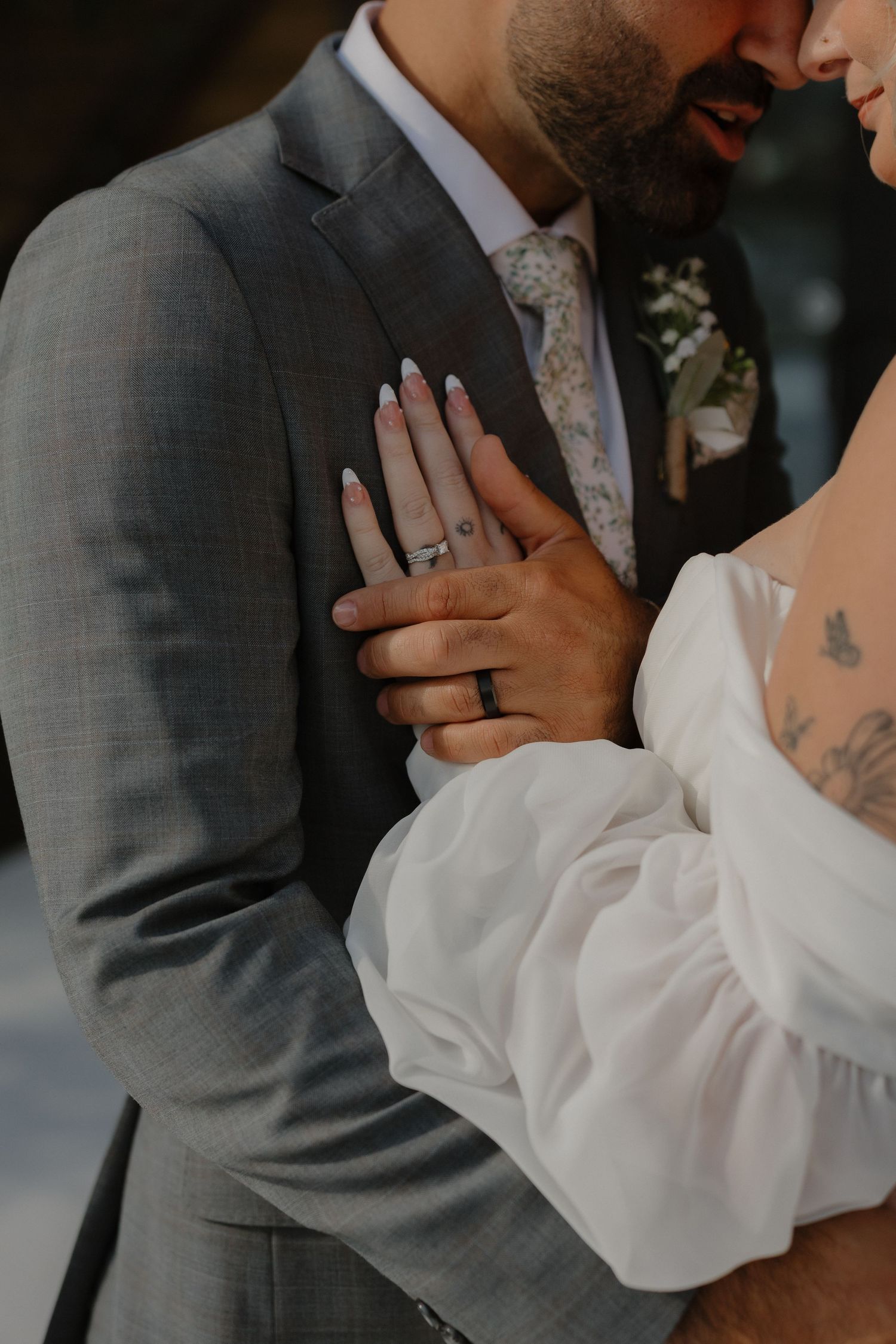 Close-up romantic wedding photos showing intimate moments between couple in gray suit and white dress.