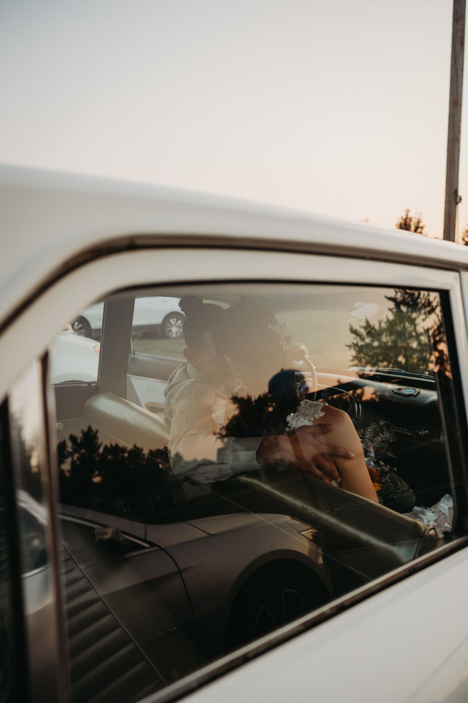 Looking through a car window during sunset while a photographer captures the moment.