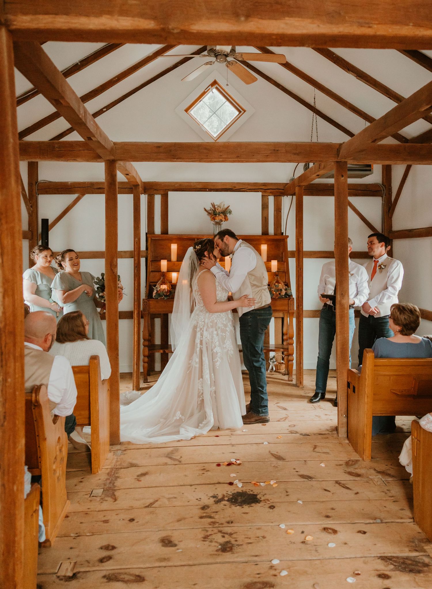 A wedding ceremony in a rustic wooden barn with exposed beams and natural lighting.
