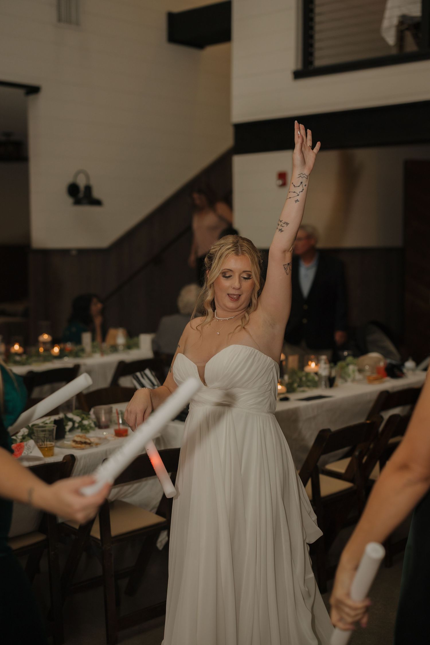 Reception venue with dancing and celebration in dimly lit indoor setting.