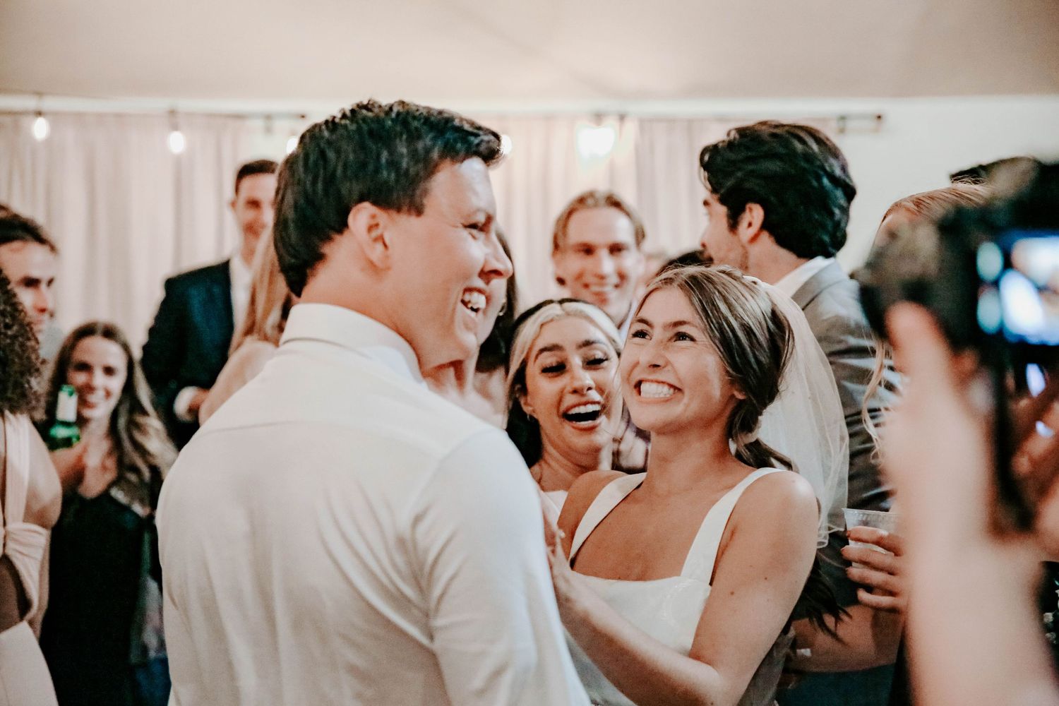 Wedding reception guests dancing and celebrating together indoors.