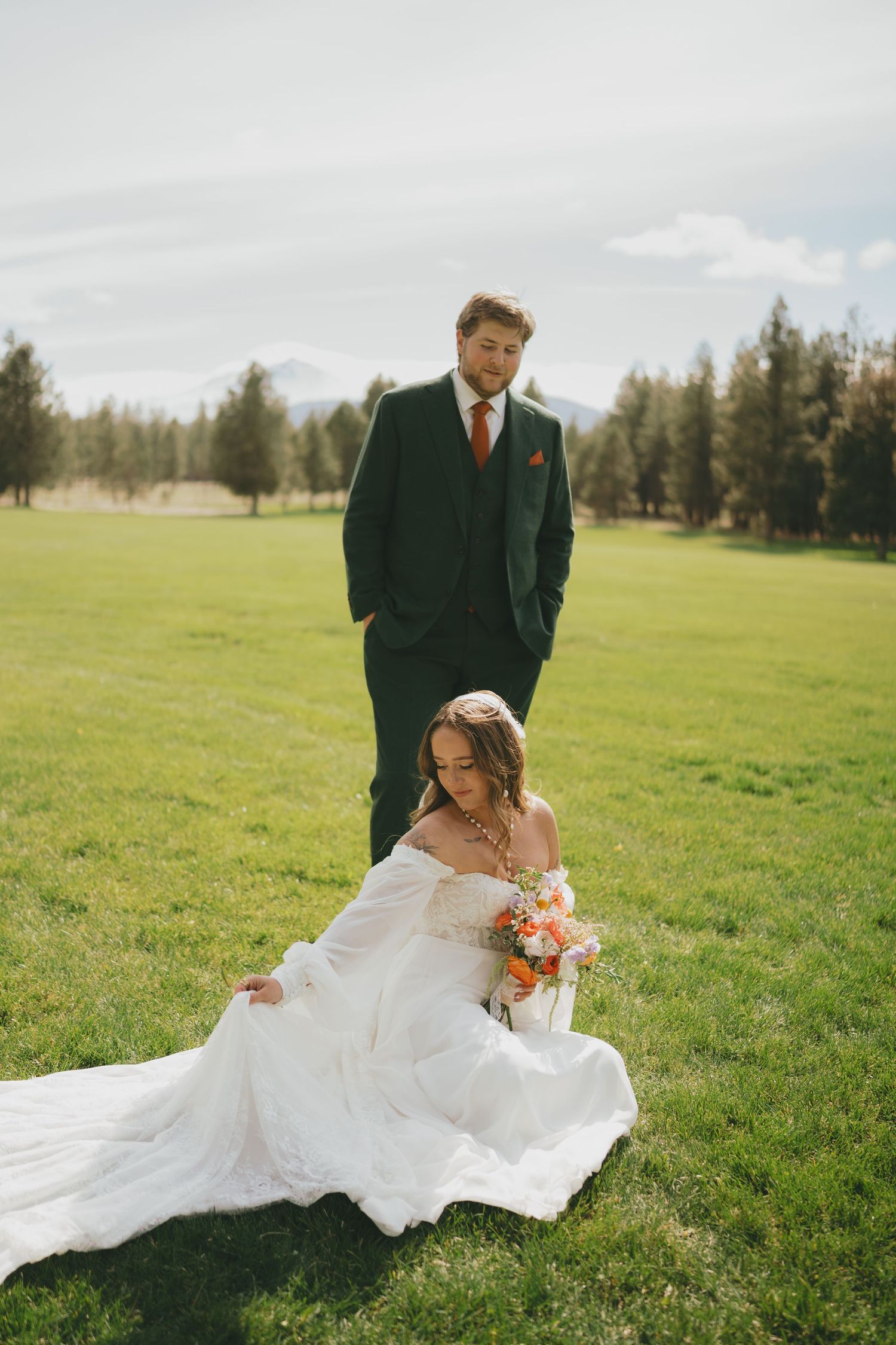 A romantic wedding photo series in a green field showing a couple in formal attire embracing on their special day.