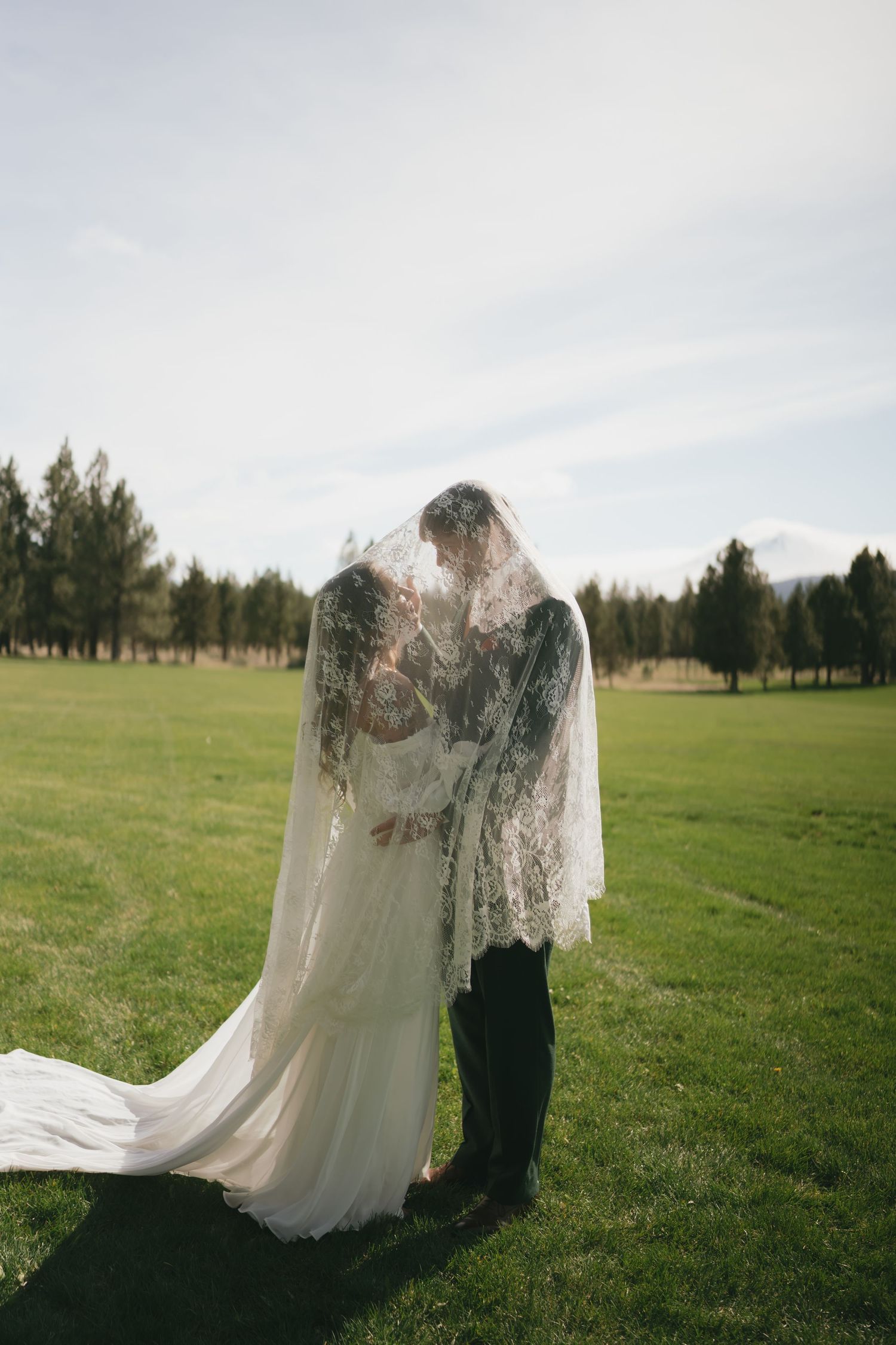 A dreamy wedding photoshoot sequence capturing tender moments between newlyweds in a scenic outdoor meadow.
