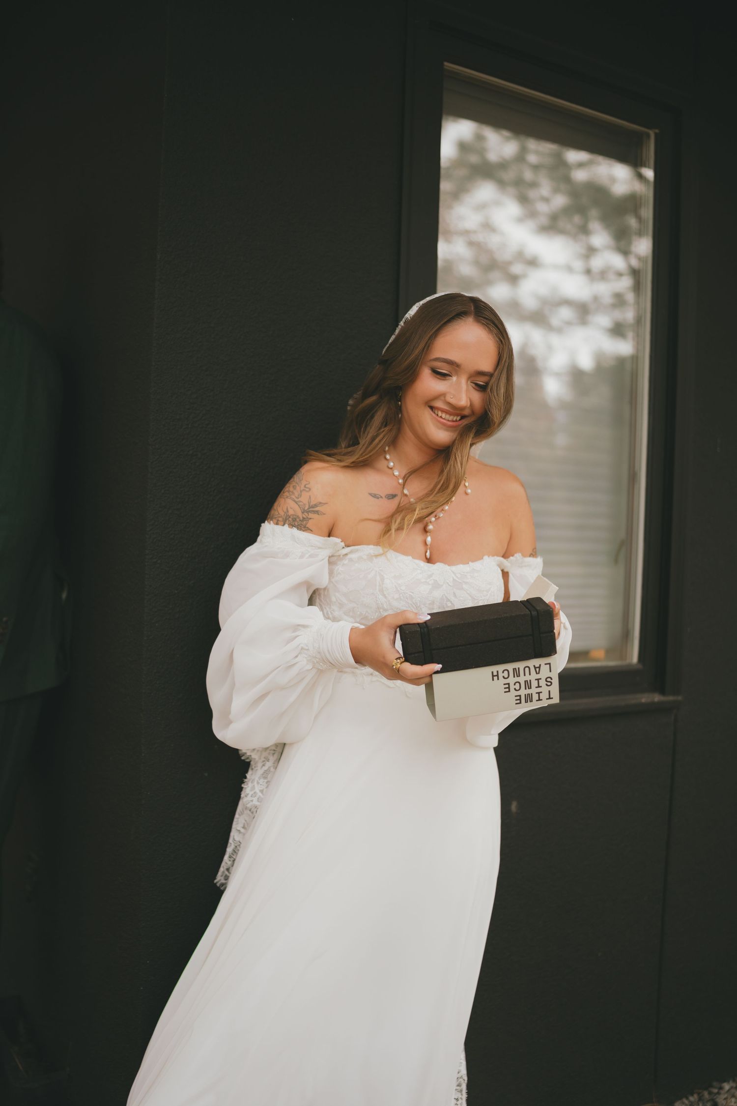A sequence of photos showing someone trying on a flowing white dress in front of a dark wall.