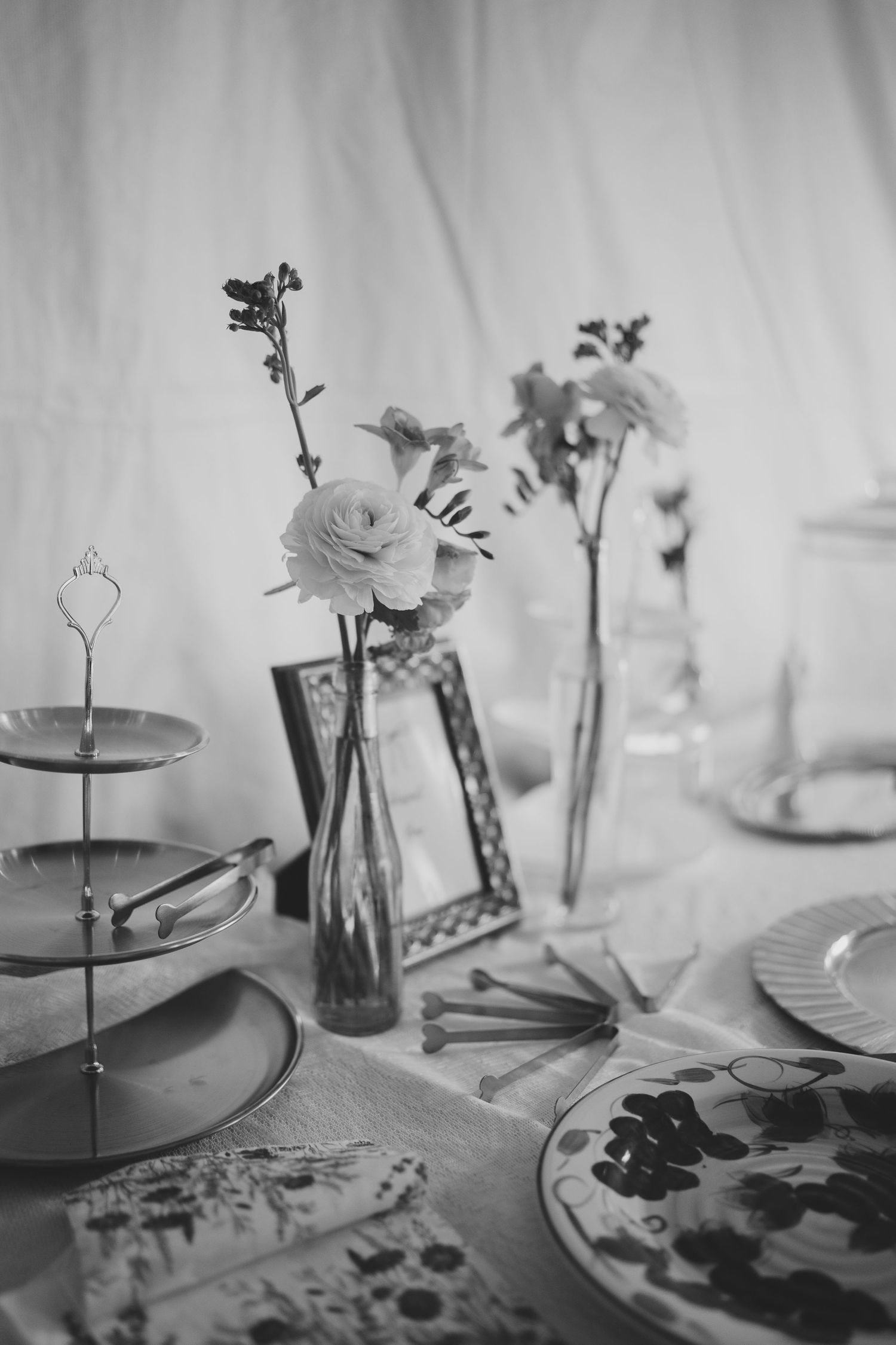 Black and white table setting with tiered serving plates and delicate floral arrangements in elegant vases. Pole creek ranch