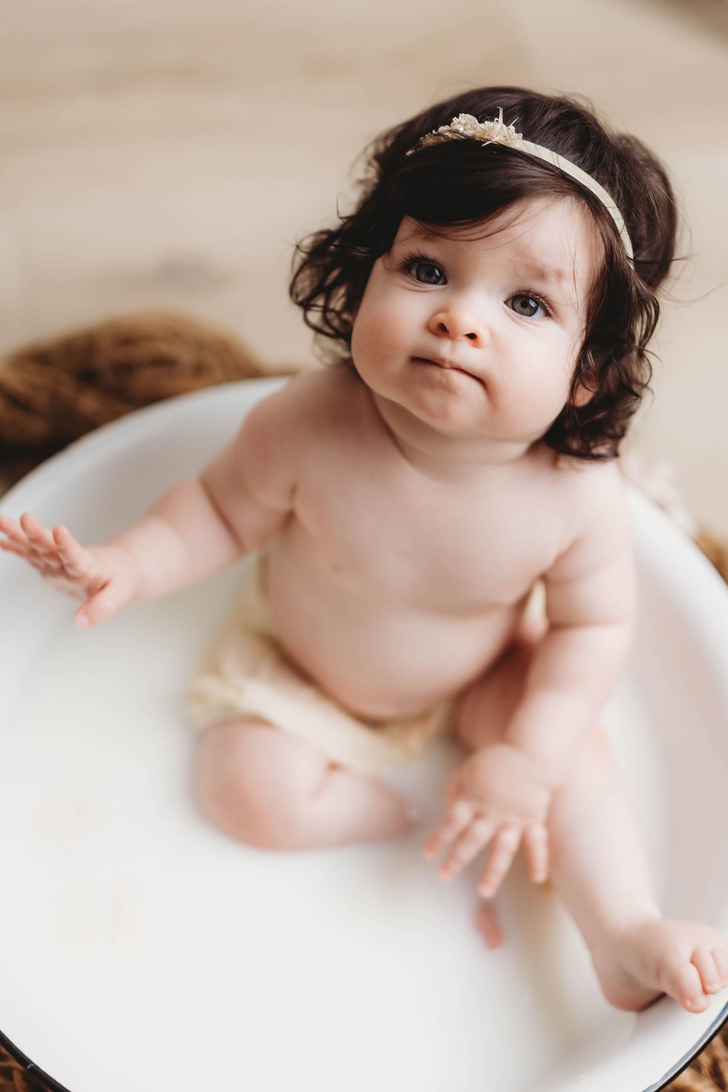 Baby bath photoshoot with soft natural lighting and white background.