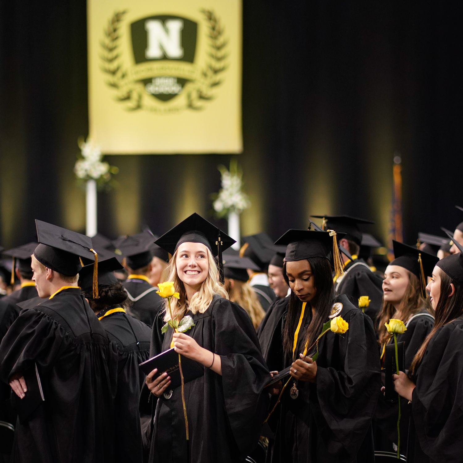 A graduate from NHS looks up at her family after receiving her diploma