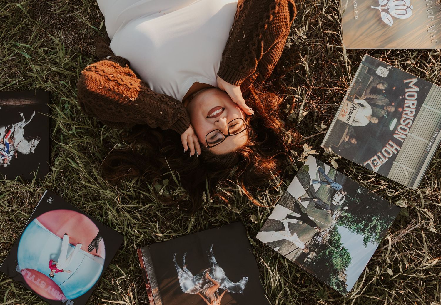 Multiple polaroid photos scattered on grass showing memories and moments captured in an artistic arrangement.