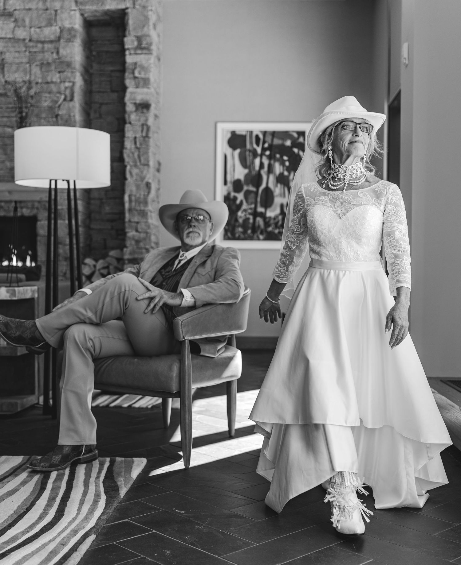 Stylish older couple in wedding attire posing in modern interior space.