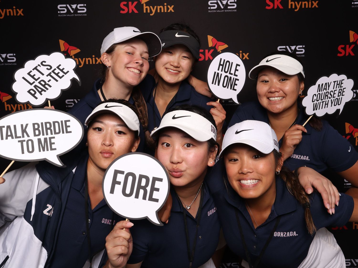 Six young women golfers pose with fun golf-themed photo booth props at an SK Hynix sponsored event.