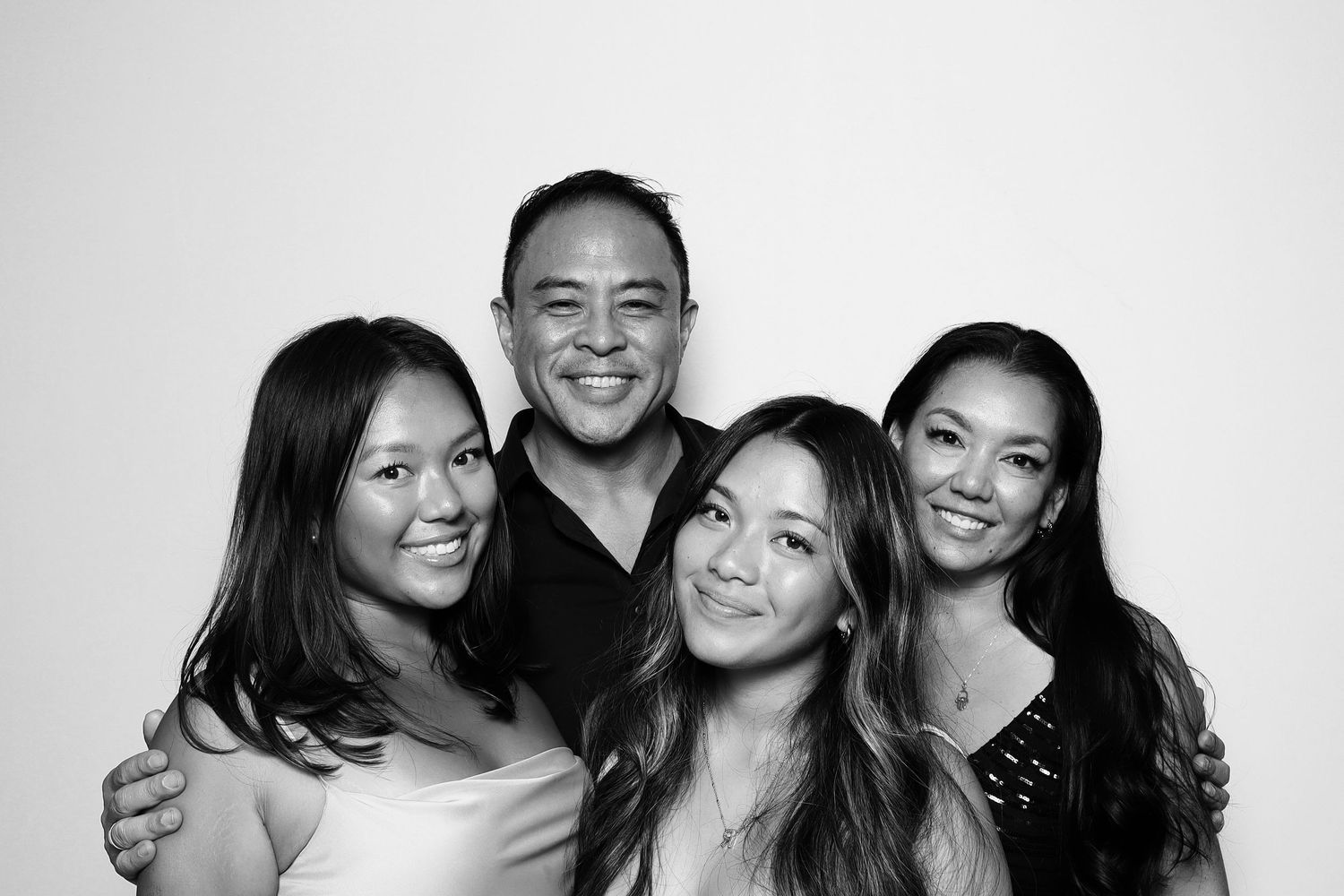 Black and white photo of a smiling man posing with three young women in a group portrait. Industrious, Walnut Creek.