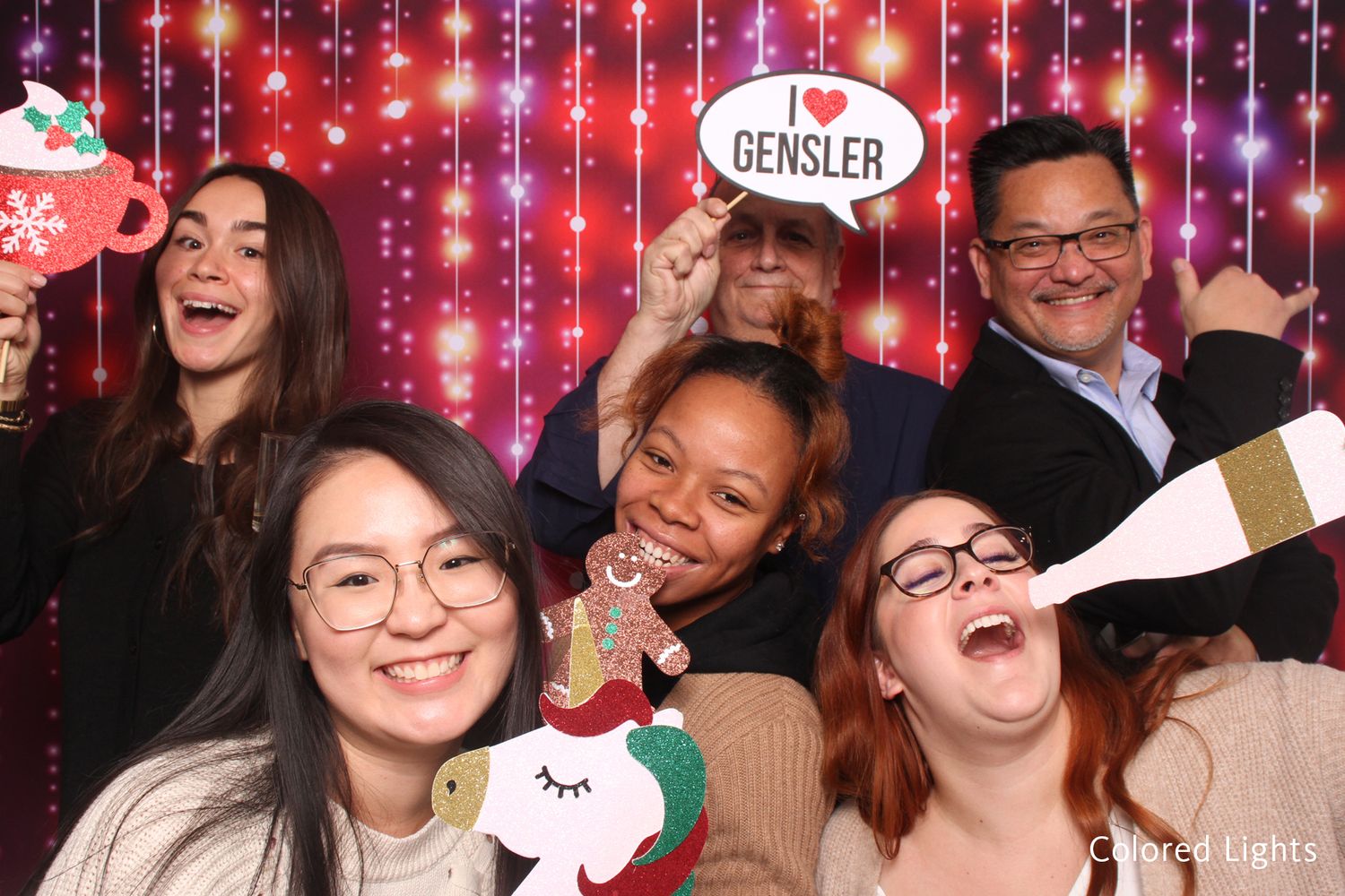 Group of five people with holiday props at Gensler Christmas party photo booth.