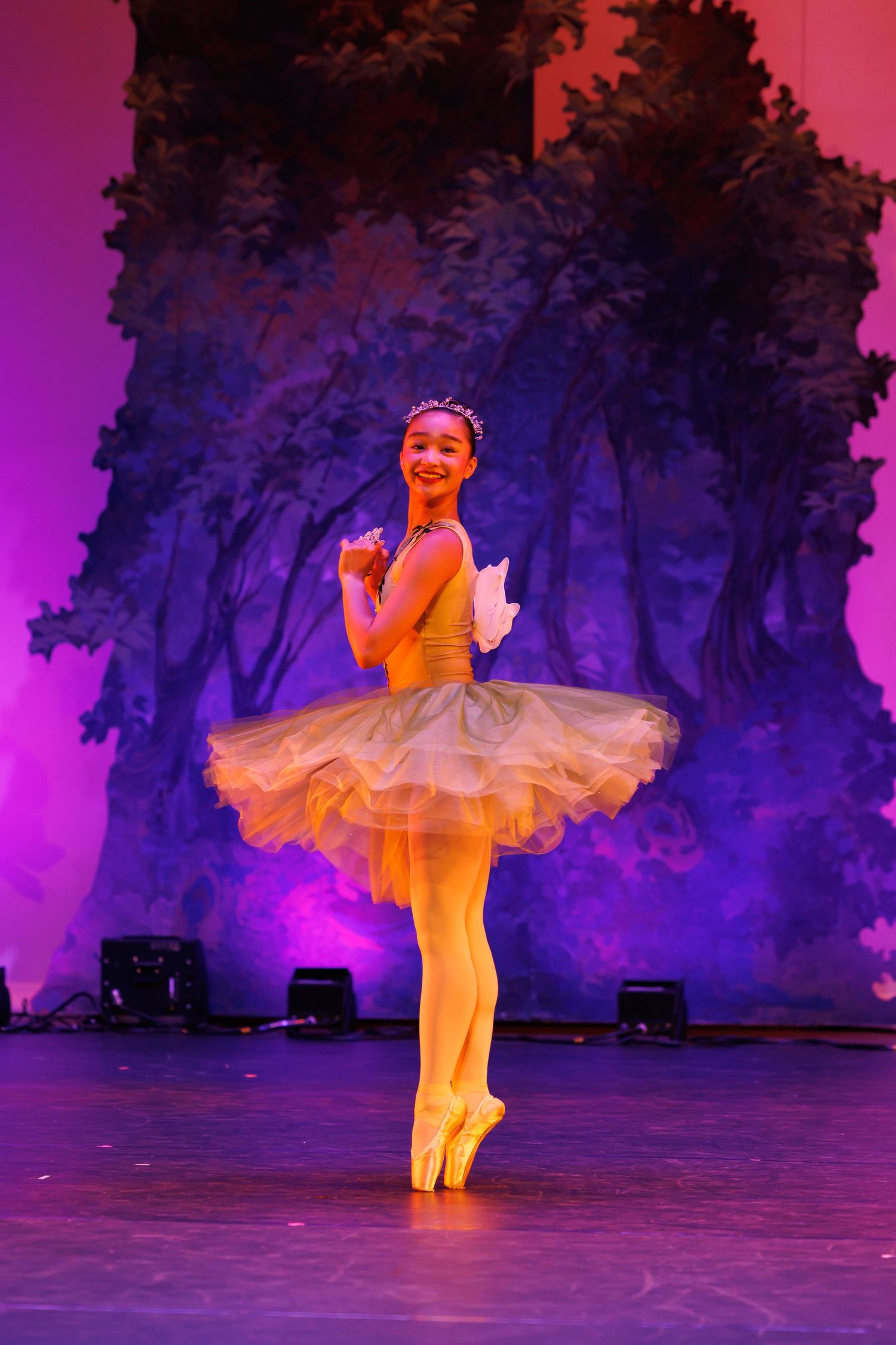 Young ballerina in yellow tutu performs gracefully on stage at Las Positas College in Livermore.