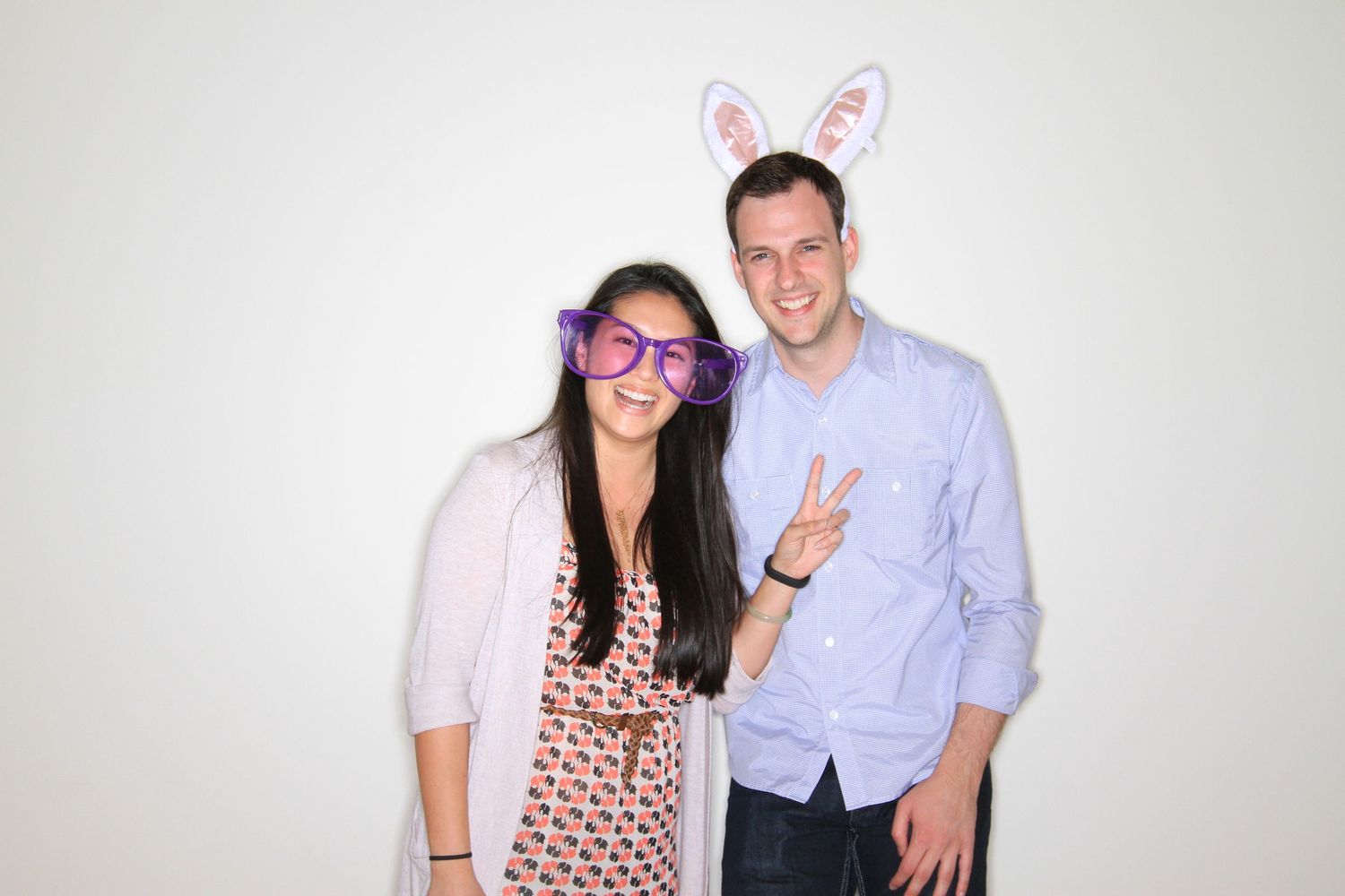 A woman wearing oversized purple glasses and a man with bunny ears smiling and posing together at a birthday in Milpitas Senior Center