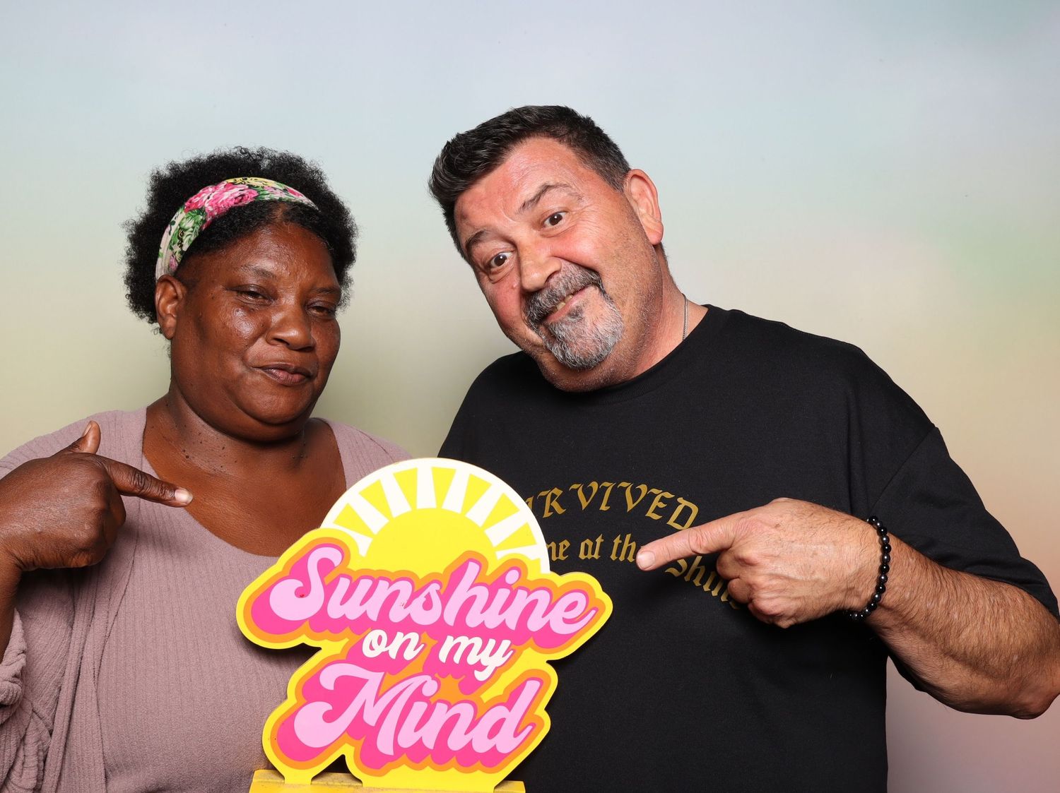 Two people posing with a colorful Sunshine on My Mind sign at a photo booth event at the Shine in Pleasanton.