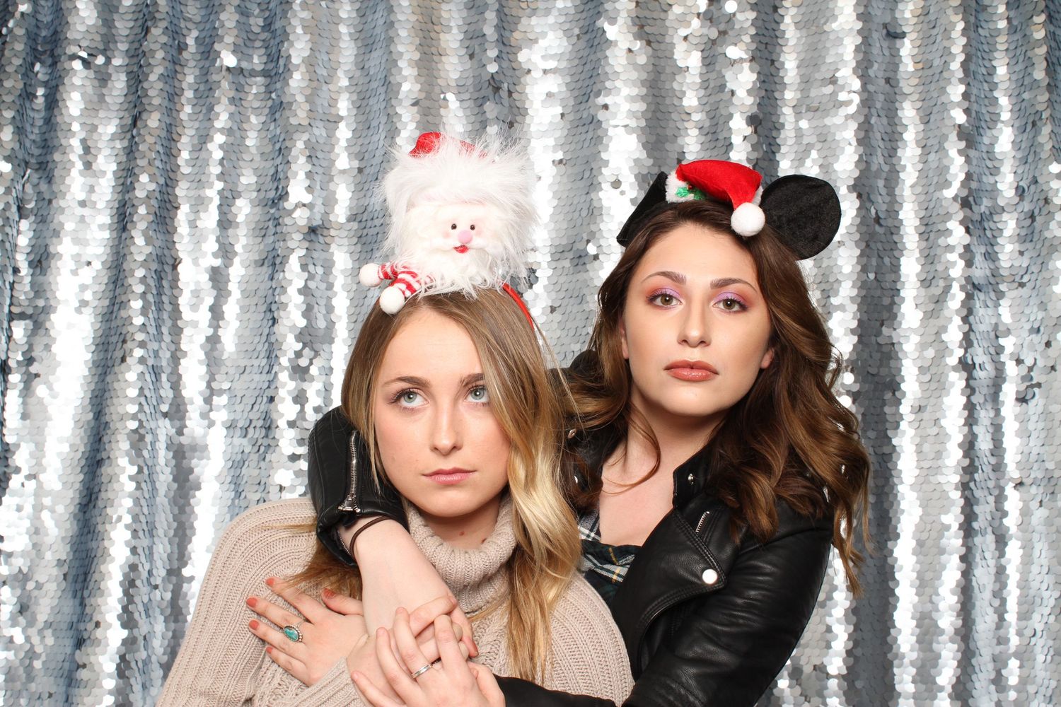 Two young women pose with festive holiday accessories at an IIDA party in San Jose, CA