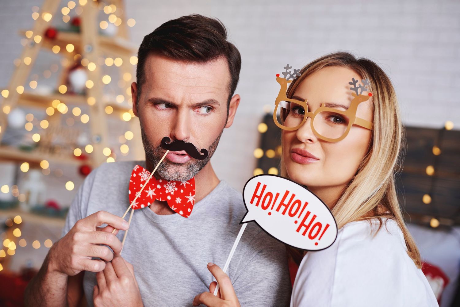 Couple posing with Christmas photo booth props using Lune photo booth at a party in San Jose, CA