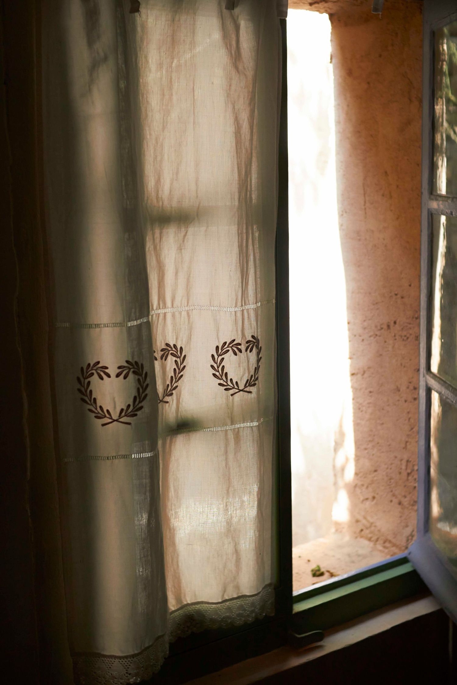 An open window with curtain in sunlight in France by Cat Heygate Photo