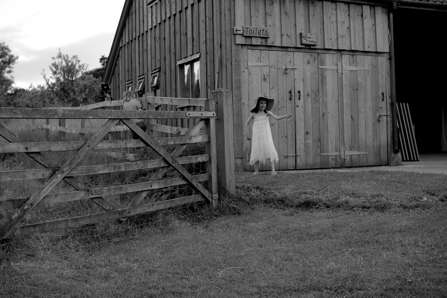 A girl by a barn wearing a hat in dorset by Cta Heygate Photo