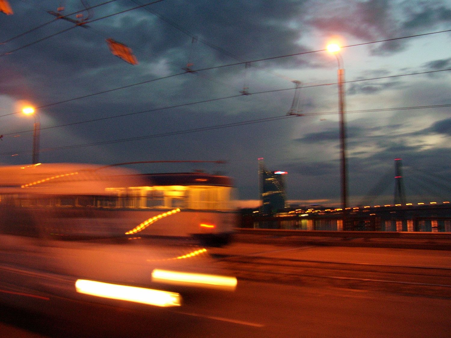 Tram with warm blurred lights against evning sky indicating movement by Cat Heygate Photo